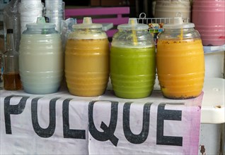 Transparent jars on table containing pulque alcoholic drink