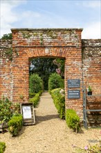 Red brick entrance to walled kitchen garden