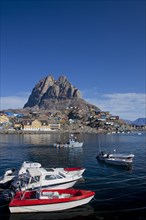 Uummannaq village with colourful houses and fishing boats in front of Heart Mountain