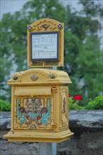 Historical yellow mailbox with ornaments