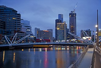 Bridge over the Yarra River and skyline with skyscrapers of the Melbourne City Centre at sunset