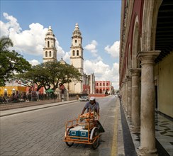 Man pushing cart in main square of Campeche city