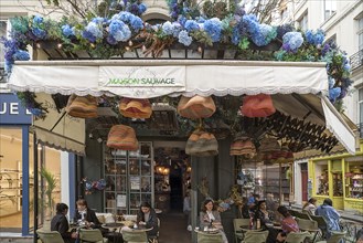 Artificial flower decorations and coffee caps above the Bistro Maison Sauvage