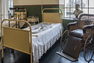 Antique wheelchair and sick beds in 19th century ward at the Hopital Notre-Dame a la Rose