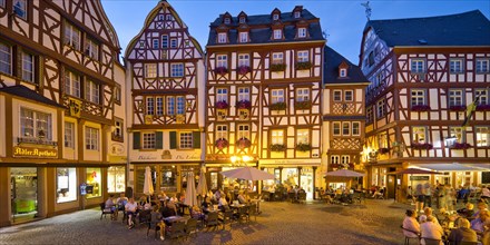 Gabled half-timbered houses on the busy medieval market square in the evening