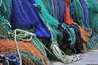 Colourful trawler fishing nets on the quay in Lyme Regis harbour along the Jurassic Coast