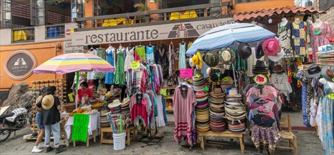 Street market stalls selling hats and clothing