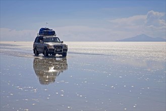 Four-wheel drive vehicle driving on the salt flat Salar de Uyuni