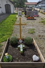 Cemetery and simple grave with praying angel