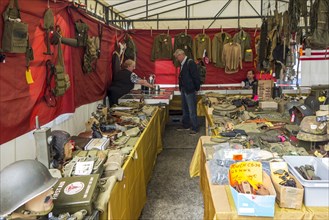 Vendor in WWII stand selling military artifacts to World War Two collector at WW2 militaria fair