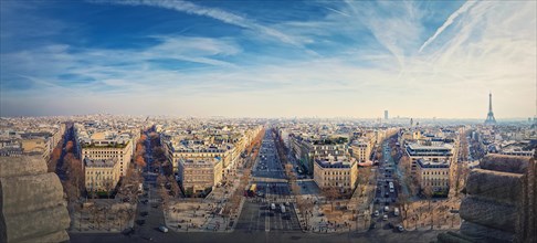 Wide angle Paris cityscape panorama from the triumphal arch with view to parisian avenues and Champs-Elysee in the center. Beautiful architectural landmarks on the horizon