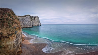 Sightseeing view to the wonderful cliffs of Etretat washed by the waves of the blue sea water