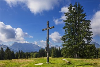 Summit cross on the Breitenberg with a view of the Osterhorn