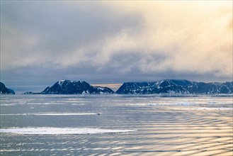 View from the sea at a rocky coastline in the Arctic with ice floe