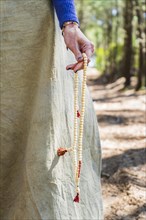Close up of a japa mala holded by a woman hand