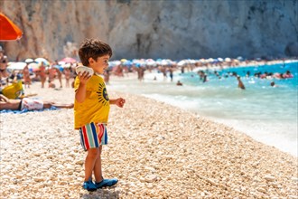Boy having fun on Porto Katsiki beach in summer vacation Lefkada island
