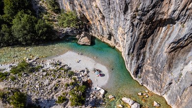 Aerial drone view of small beach on turquoise river of Valbona valley
