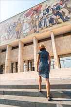 A female tourist walking up the stairs to the National Historical Museum in Skanderbeg Square in Tirana. Albania