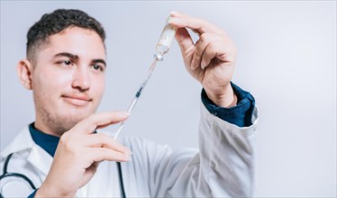 Closeup of doctor holding syringe and antidote isolated. Smiling doctor holding syringe with antidote on isolated background
