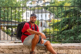 Portrait of a tourist sitting resting on a viewpoint the city of Gjirokaster or Gjirokastra. Albanian
