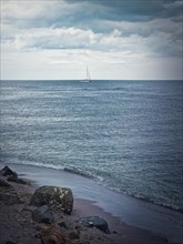 Seascape with a sailboat on the horizon. Bulgarian coastline of the Black Sea