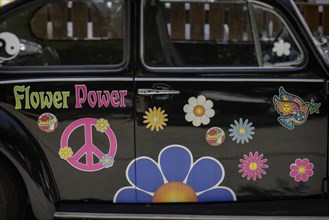 Flowers and peace symbols on car doors in Matala