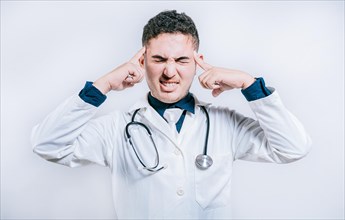 Doctor with migraine holding his head. Fatigued doctor with headache isolated