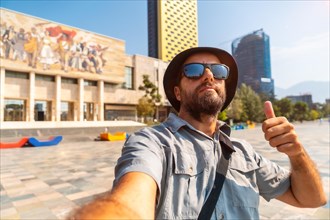 Selfie of a tourist blogger at the entrance to the National Historical Museum in Skanderbeg Square in Tirana. Albania