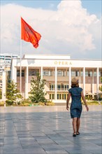 A tourist woman at the entrance to the Palace of Culture or Opera on Skanderbeg Square in Tirana. Albania