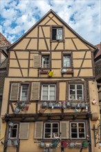 Facade of a traditional Alsatian house decorated with old water jugs