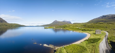Aerial panorama of the freshwater loch Loch Assynt with the ruins of Ardvreck Castle
