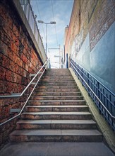 Outdoors staircase behind the buildings walls. Abstract view upstairs