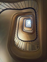 Abstract shape spiral staircase. A look up to the hypnotic stairwell