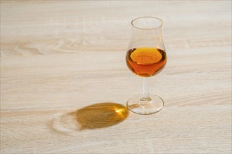 Cognac in sniffer glass under harsh sunlight