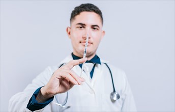Closeup of doctor holding and showing a syringe isolated. Caucasian doctor holding a syringe on isolated background