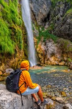 Man with backpack at Grunas waterfall in Theth national park