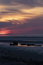 Dramatic sunset over the mudflats at low tide on the beach of Cuxhaven