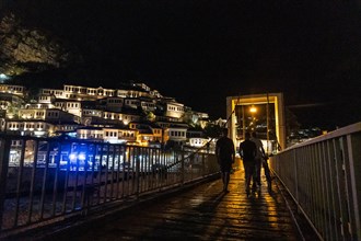 Walking on the bridge of the illuminated historic city of Berat in Albania