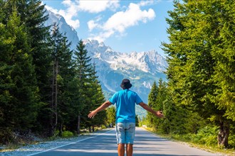 A tourist in summer walking on the road in the Valbona valley