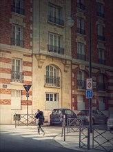 Outdoors scene with a person crossing the street on the crosswalk in Asnieres sur Seine