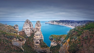 Beautiful panoramic view to the Etretat village and beach resort from the famous Falaise d'Aval cliffs in Normandy
