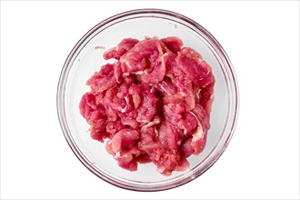 Top view of glass bowl with raw chopped pork tenderloin isolated on white background