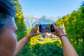 Woman Photographing The Historical Grandhotel Giessbach on the Mountain Side in Brienz