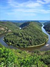 Aerial view of the Saar Loop. The Saar winds through the valley and is surrounded by green forests. Orscholz