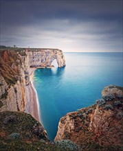 Idyllic view to Porte d'Aval natural arch at Etretat famous cliffs washed by Atlantic ocean