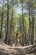 Woman with open arms enjoying nature. Freedom concept. Vertical shot