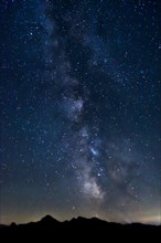 Starry sky with the Milky Way above the highest mountain of the Chiemgau Alps