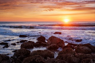 Atlantic ocean sunset with waves and rocks at Costa da Caparica