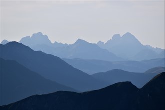Backlit silhouettes of the mountain ridges and peaks of the Dolomites