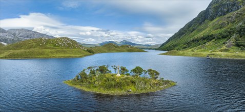 Aerial panorama of a small island with a Celtic stone cross in the freshwater loch of Loch Stack in the Northern Highlands
